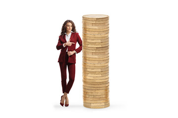 Businesswoman pointing at a tall pile of coins