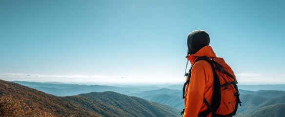The adventurous hiker overlooking stunning mountain vistas under a clear blue sky.