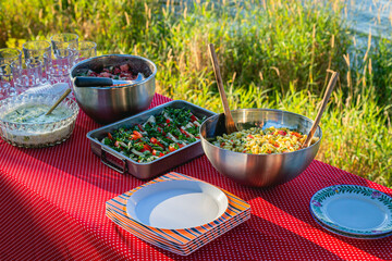 Outdoor picnic table with salads and plates