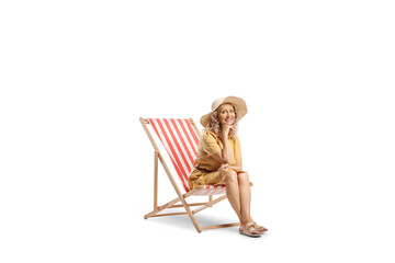 Middle aged woman sitting on a deck chair and smiling