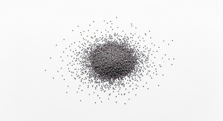 Obraz premium A pile of tiny dark roughly spherical seeds scattered on a clean bright white surface
