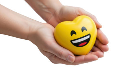 Hands holding a bright yellow heart shaped stress ball with a smiling emoji face, isolated on white background.