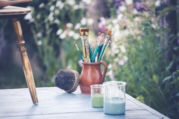 Painting a wooden furniture outdoors, an eco-friendly re-use business.