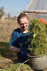 Young man engaged in household chores and small-scale rural farming, tending to his garden with...