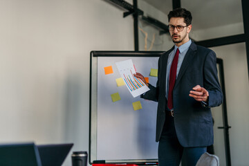 Businessman showing charts and statistics at corporate meeting