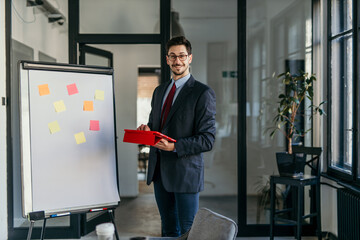 Businessman using digital tablet while giving presentation in office meeting room