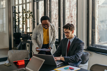 Business people working together on laptop in office meeting