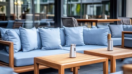 Outdoor patio furniture, light blue cushions, wooden tables
