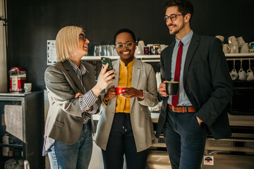 Business people enjoying coffee break and using smartphone