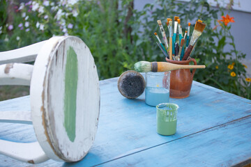 Painting a wooden furniture outdoors, an eco-friendly re-use business.