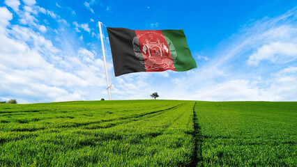 Afghanistan Flag waving on a tall pole over a green field and blue sky