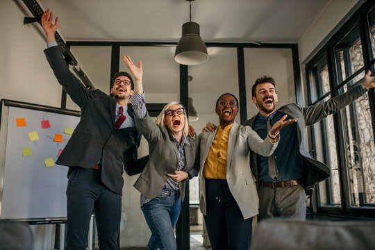Excited business team celebrating success in modern office