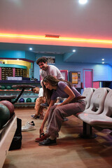 Group of friends wearing bowling shoes, preparing to play a bowling game