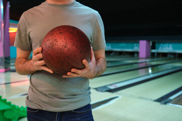 Man holding bowling ball in bowling club, ready for a strike