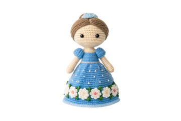 Handmade crocheted doll with brown hair wearing blue dress decorated with white flowers and green leaves trim, isolated on a transparent background