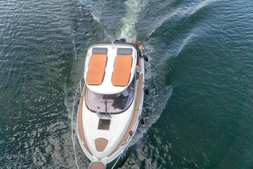 Aerial view of modern fishing boat with family of anglers on the deck. Summertime, calm sunny weather.