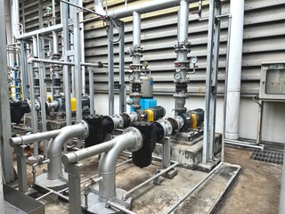An industrial pumping station with various pipes, valves, and gauges, highlighting the complex...