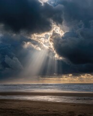 Obraz premium Dramatic sunlight piercing dark clouds over a beach (1)