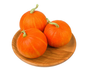 three Pumpkin Red Kuri (Potimarron) decorative pumpkins close-up on a wooden bowl isolated on a white background