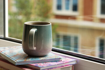 A cup of coffee on the balcony for relaxation. Breakfast in the morning against the background of house windows. Coffee on the city streets.