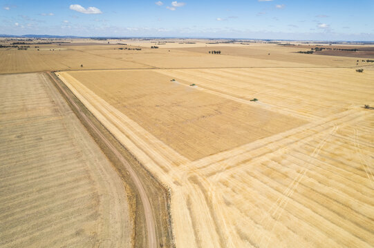 Aerial view of a vast farmland with distinct areas of varying shades of brown and beige.