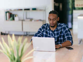 African American Man Calling While Working on Laptop