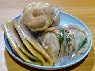 Various typical Indonesian market snacks, on white plates, displaying detailed textures and colors of traditional snacks.