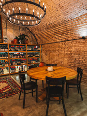 Cozy bar corner with round table, wine shelves, and paintings