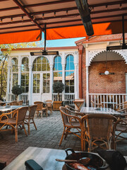 Warm wooden restaurant terrace with evening lights and tables