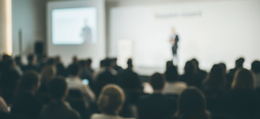 Obraz premium Blurred image shows a speaker presenting to an audience in a conference room.