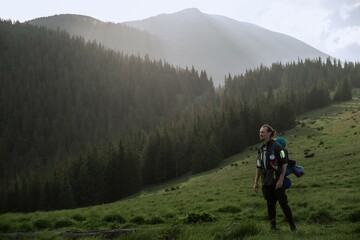 Fototapeta premium Hiker Exploring Carpathian Mountains with backpack standing in the sunset