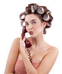 Woman with hair curlers using a vintage telephone while blowing a kiss at the camera. Concept of...