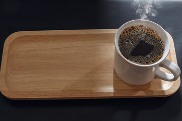 Hot black coffee cup on an empty wooden tray