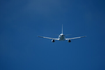 The plane moving away after takeoff. Airplane flying in the blue sky. 