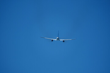 The plane moving away after takeoff. Airplane flying in the blue sky. 