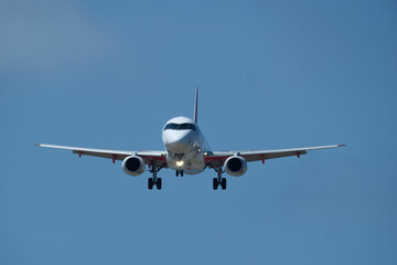 The plane approaching the airport. The plane is preparing to land. Airplane in the blue sky.