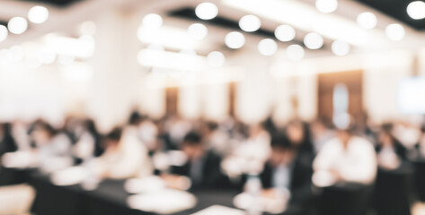 Blurred image of a conference room with people attending a meeting.