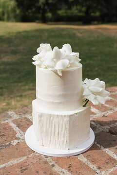 white, modern wedding cake with flowers and white roses