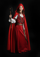 dramatic portrait of pretty young female brunette  model wearing a red hooded fairytale cloak and...