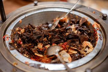 Indonesian cuisine Dendeng Balado in a buffet chafing dish. Spicy fried beef jerky with chili, traditional Padang food served at a wedding.