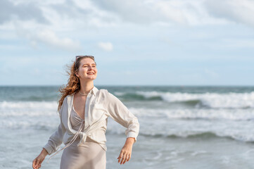 young carefree woman in casual outfit walking in sea shore,happy caucasian female tourist in seashore on summer vacation