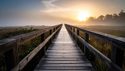 Obraz premium Sunrise Over Misty Wooden Walkway Through Marsh