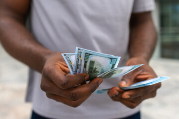 Man hands holding money dollar bills on urban street outdoor. Businessman hands counting currency...