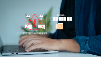 Hands typing on a laptop with system warning alert and loading error icons, representing data failure, cyber threat, and technology risk.