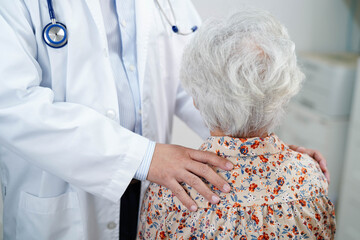 Doctor taking care, help and encourage Asian elder senior woman patient in clinic hospital.