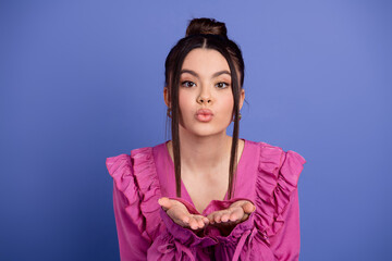 Beautiful brunette woman in stylish pink ruffle dress with playful expression, presenting happiness...