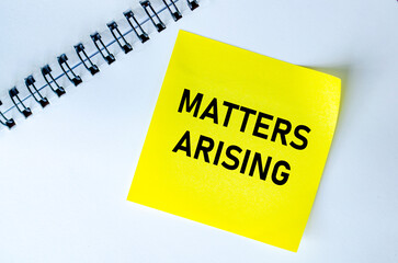 Matters Arising text on yellow notepad. Meeting agenda concept