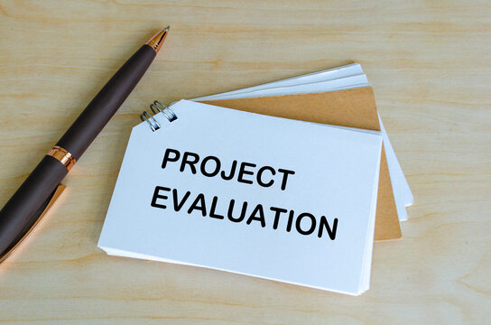 Project Evaluation text on white notepad. Project planning and evaluation concept