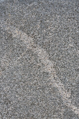 Granite texture. Natural gray granite with a grainy pattern. Stone background. Solid rough surface of rock. Durable construction and decoration material. Close-up.