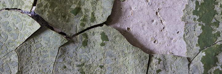 Peeling paint on the wall. Panorama of a concrete wall with old cracked flaking paint. Weathered...